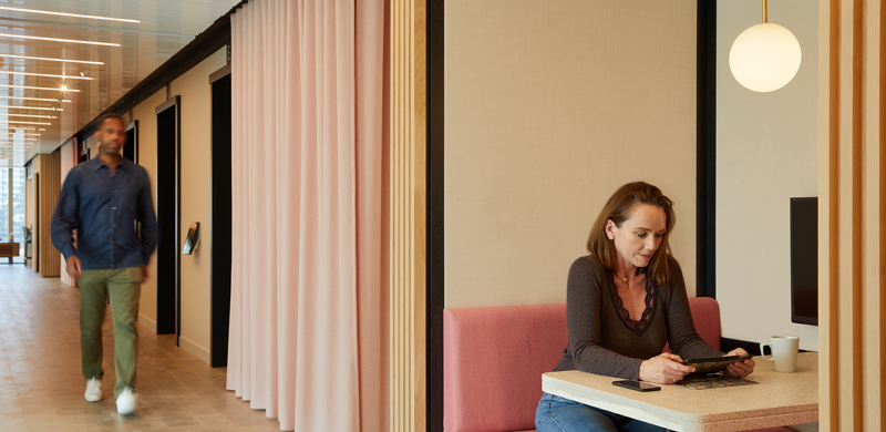 Private booth at MYO Liverpool Street featuring blush pink upholstered seating, soft lighting and semi-enclosed surroundings designed for focused work or informal meetings.