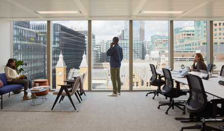 Open-plan workspace at MYO Liverpool Street featuring dedicated desks, lounge seating and floor-to-ceiling windows overlooking London's city skyline.