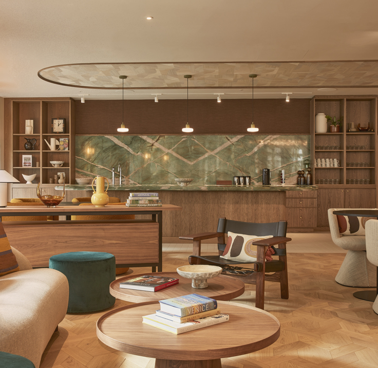Sophisticated MYO lounge space featuring curved cream seating, timber furniture, marble-effect bar detailing, herringbone flooring and warm ambient lighting.