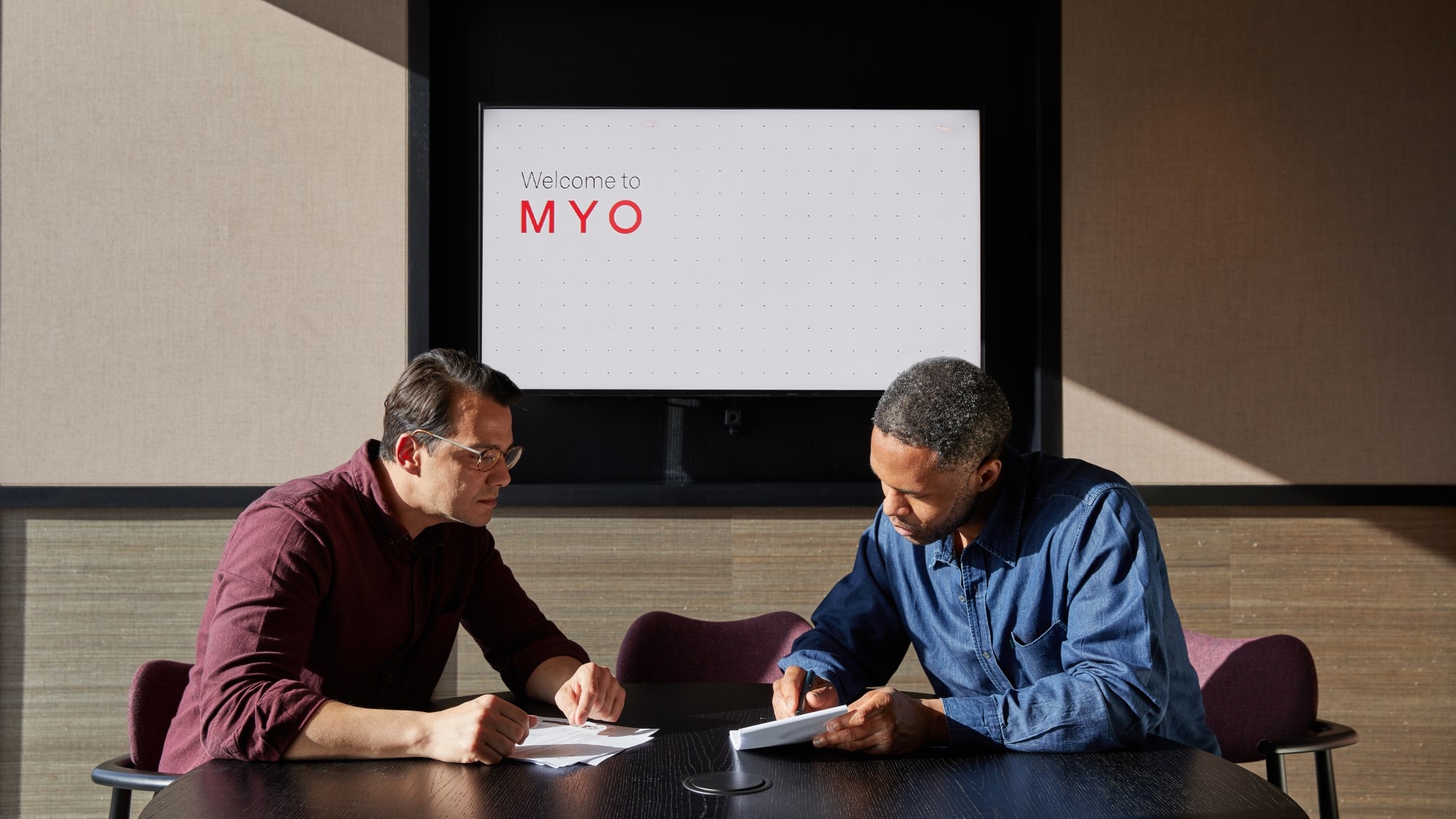 Two professionals meet in The Hub meeting room