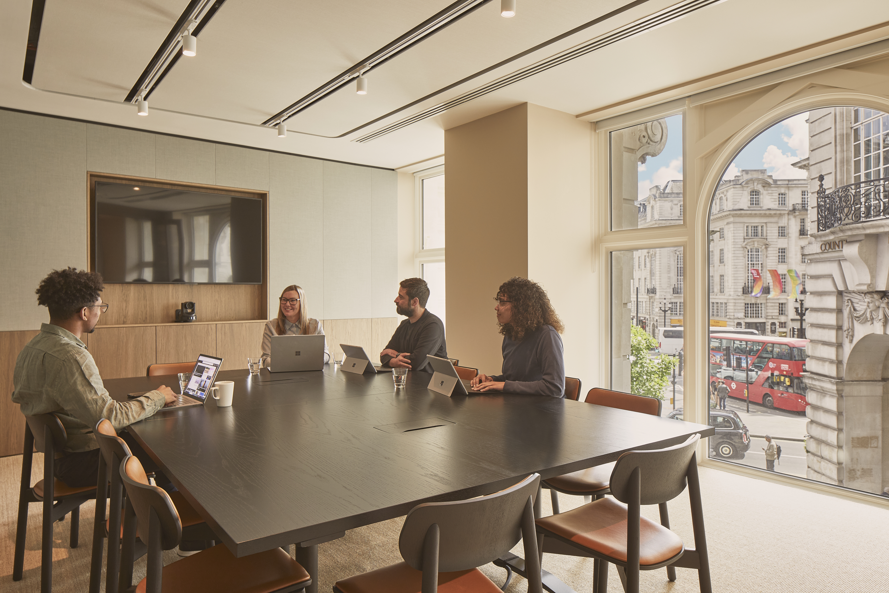 Four professionals have a lively meeting in the Lucent Lounge