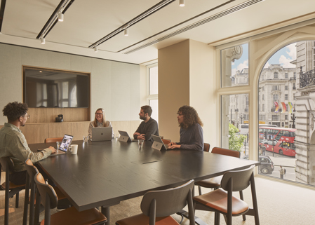 Four professionals have a lively meeting in the Lucent Lounge